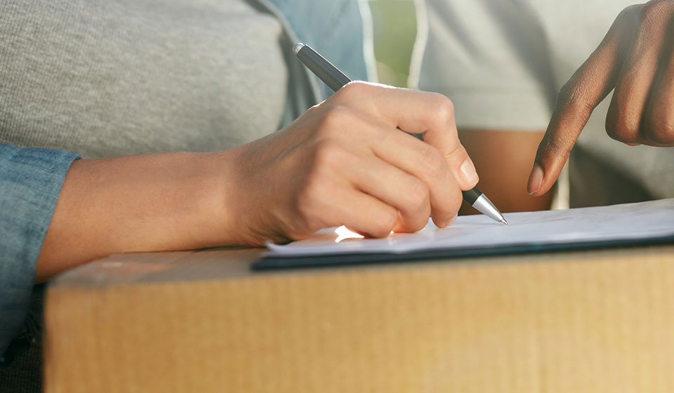 Woman signing form on a parcel
