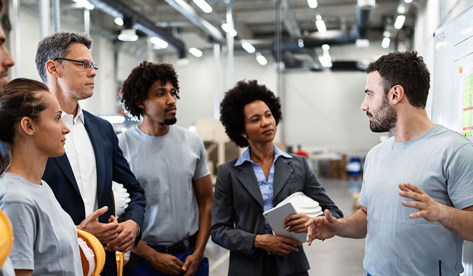 Warehouse team having a meeting in front of a whiteboard